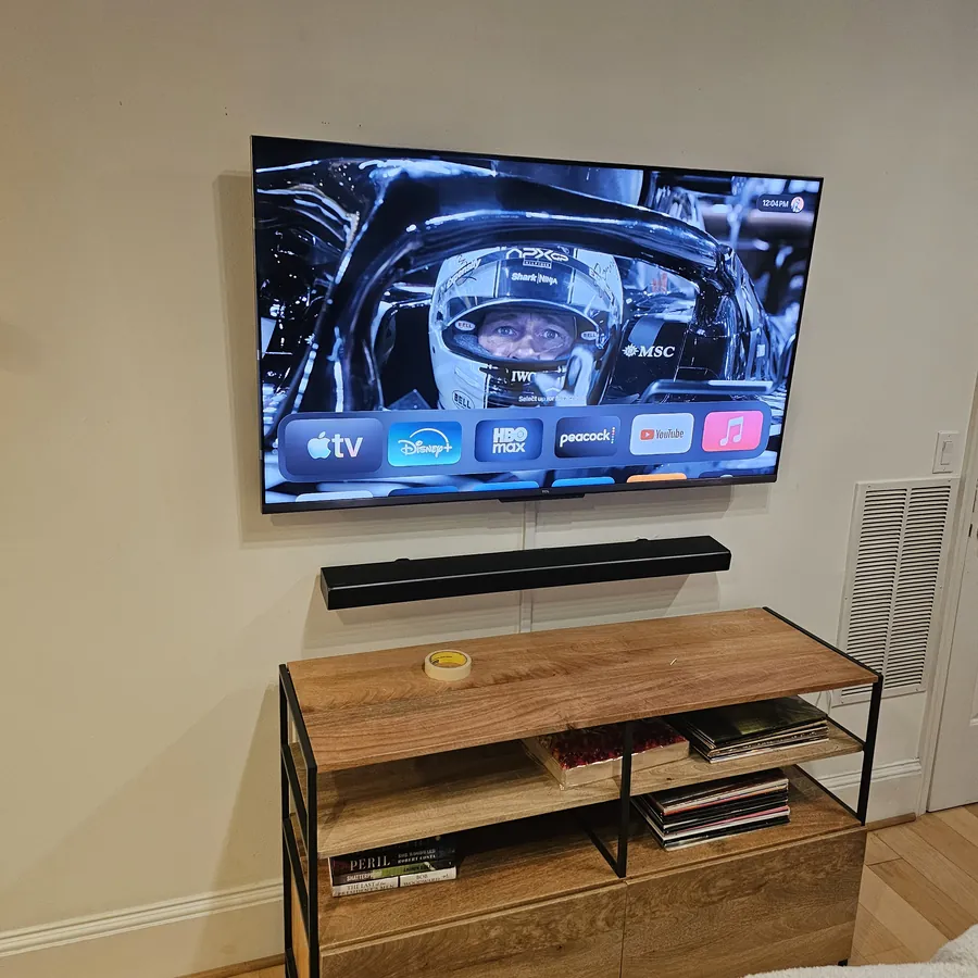 Wall-mounted television with a soundbar mounted and centered directly beneath it