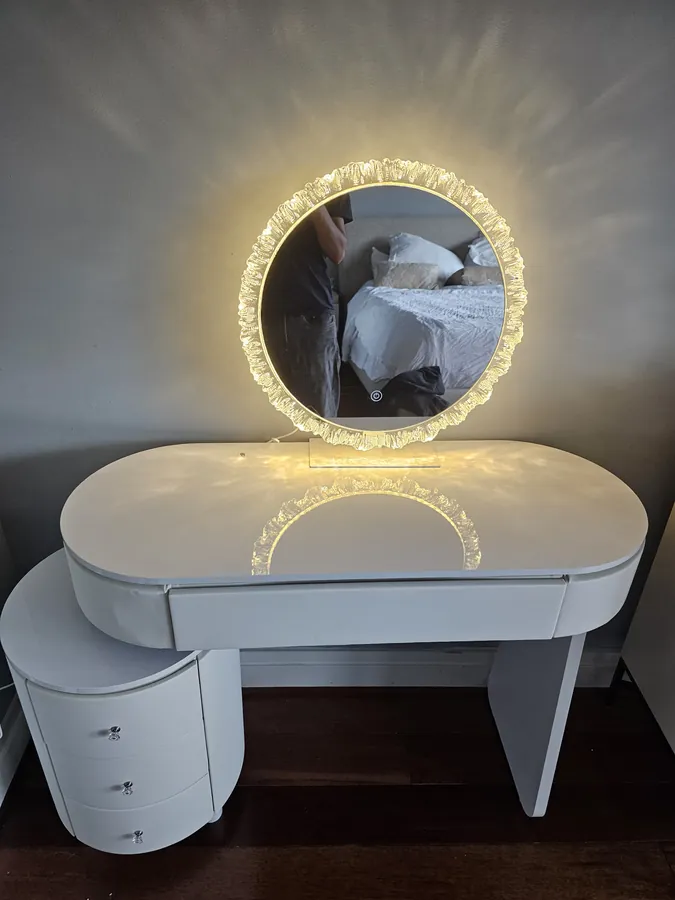 Assembled bedroom vanity with a round backlit mirror switched on